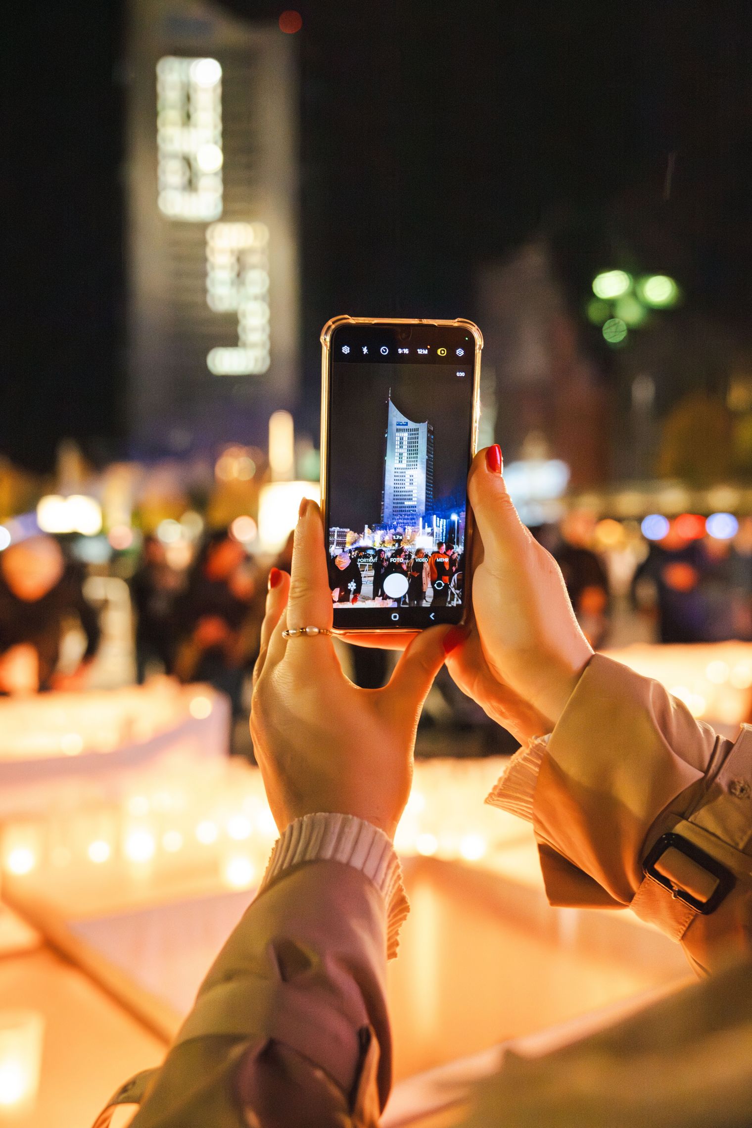 Pressefoto Lichtfest Leipzig mit City-Hochhaus und Smartphone