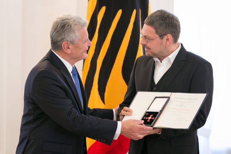 Bundespräsident Joachim Gauck überreicht Tobias Hollitzer das Bundesverdienstkreuz. Quelle: Yorck Maecke