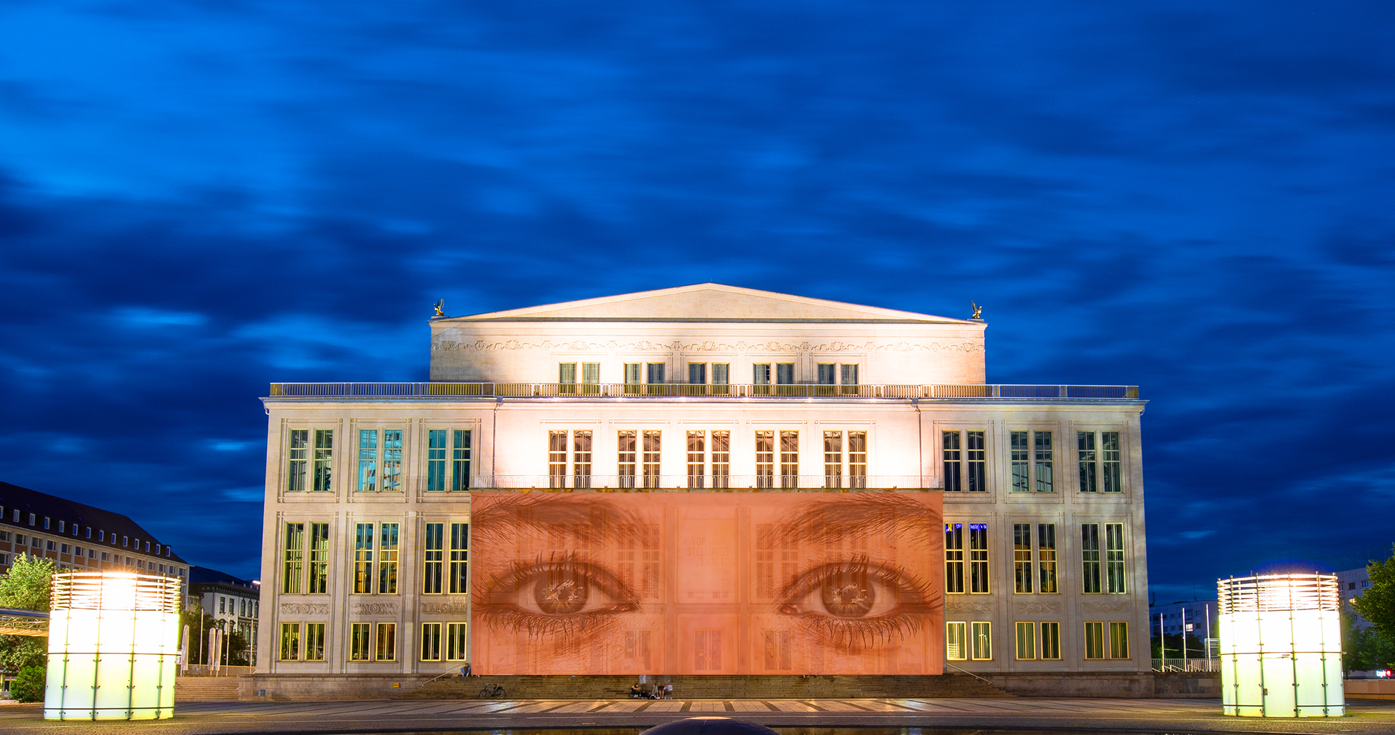 Überdimensionale Augenpaar blicken von der Oper auf den Augustusplatz